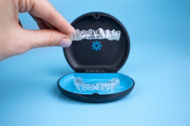 Eine Frau hält eine Invisalign Zahnschiene in der Hand