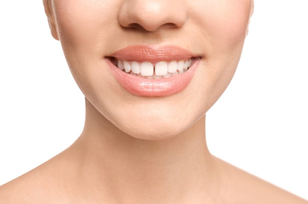 Frau mit Diastema zwischen den oberen Vorderzähnen vor weißem Hintergrund, Nahaufnahme
